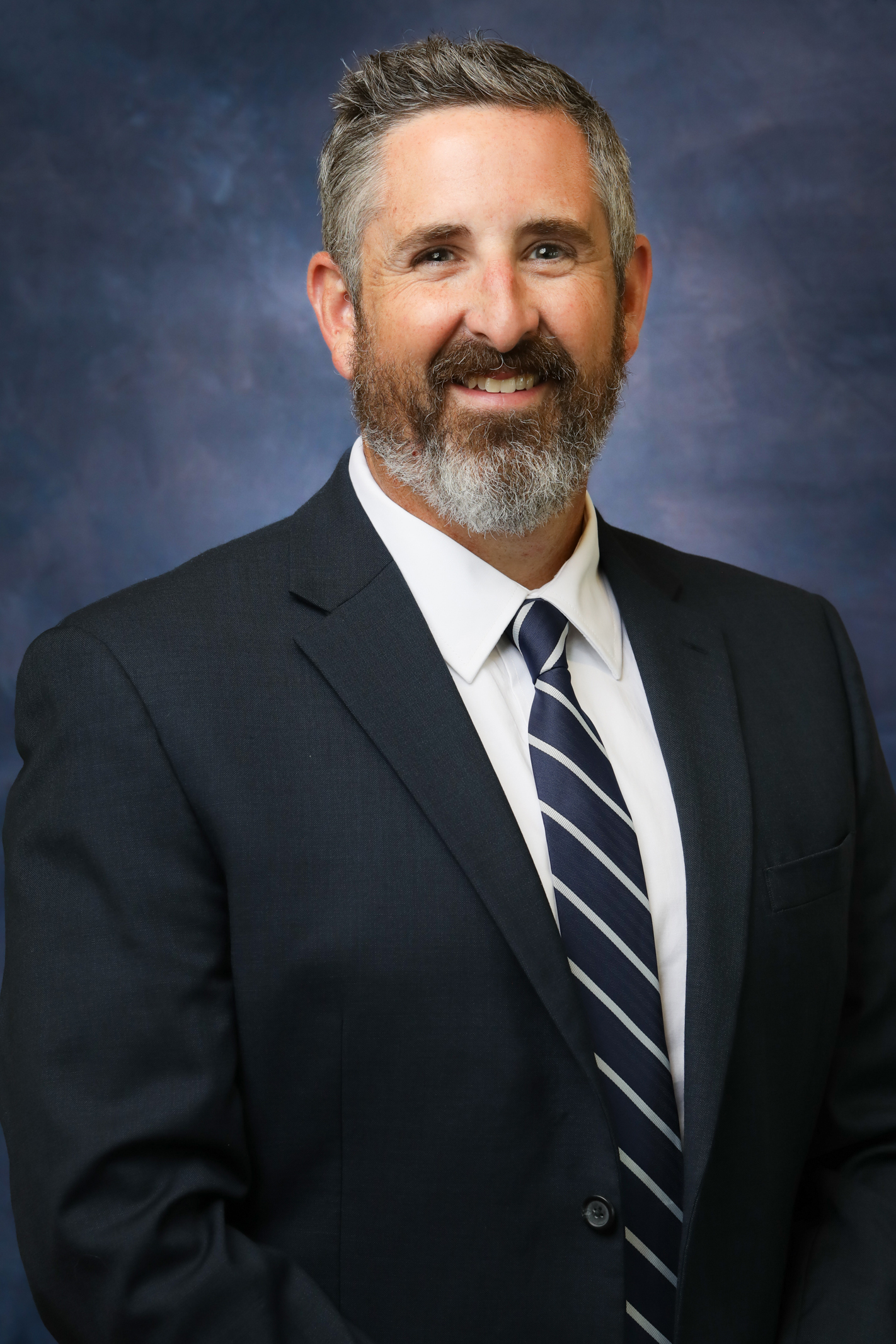 A man with grey hair and a bushy beard