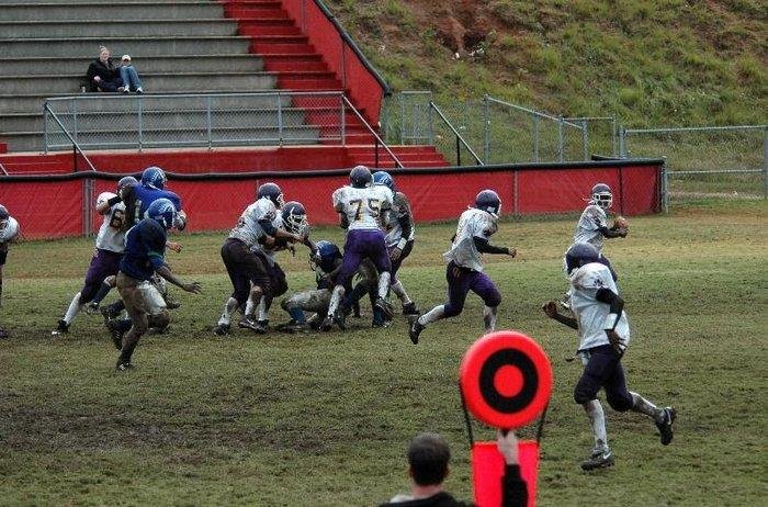 football players running plays on the football field during a game