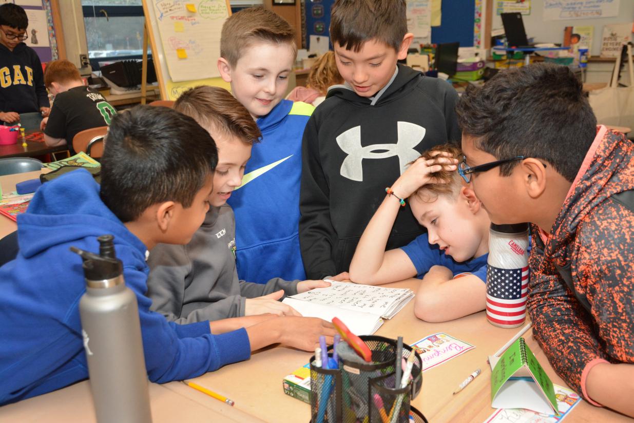 students all helping each other looking at a piece of paper