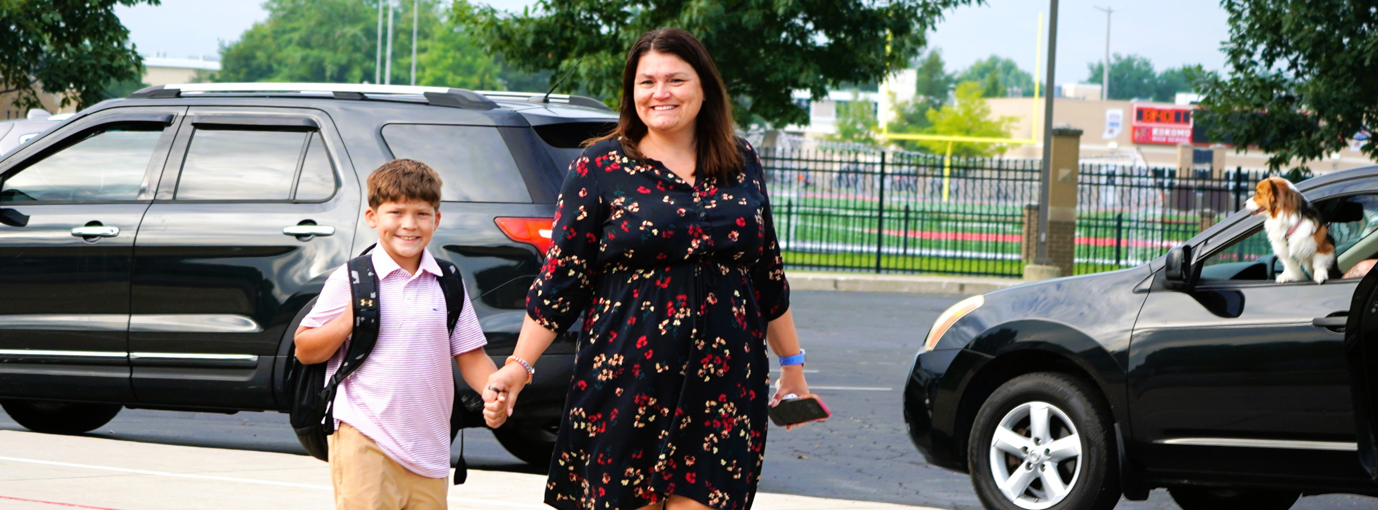 Mom and son both smiling and walking to school