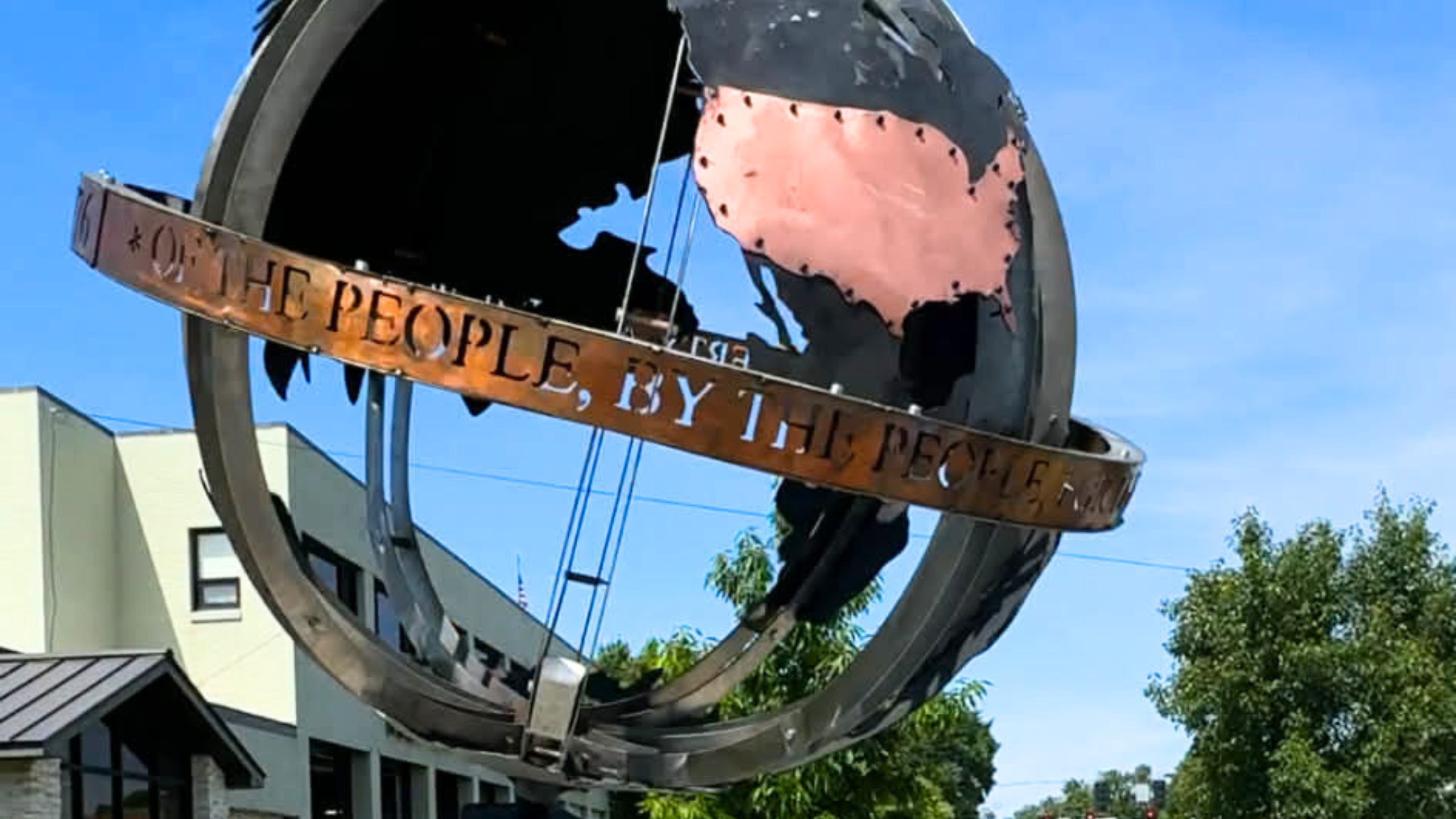 metal globe sculpture with inscription "of the people for the people"