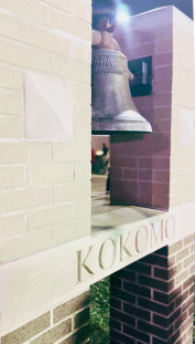 Brick structure with large vintage iron bell and the word Kokomo