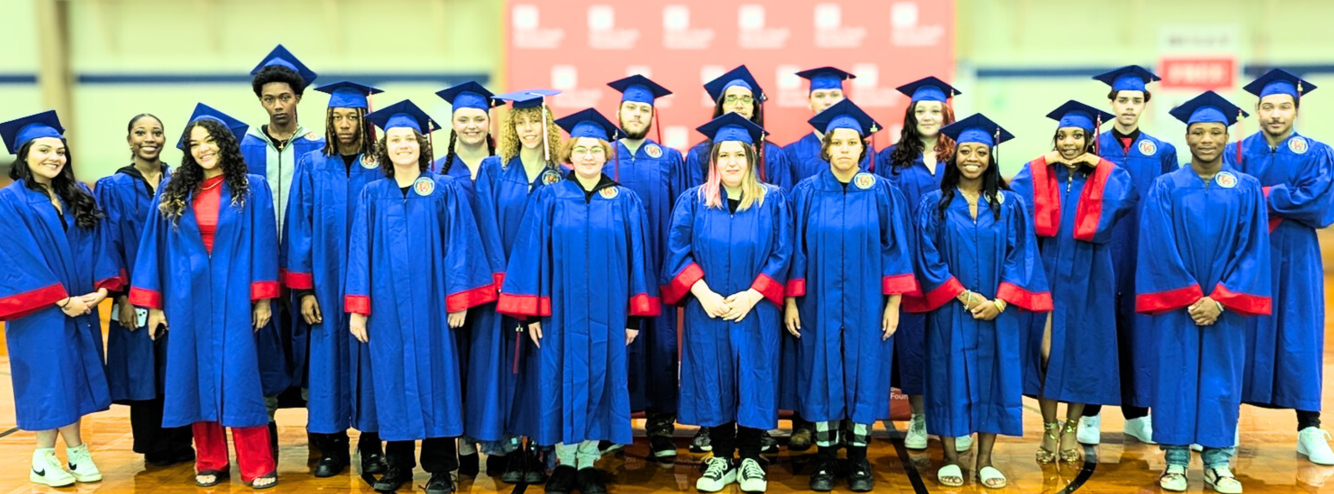 Students in blue caps and gowns at high school graduation