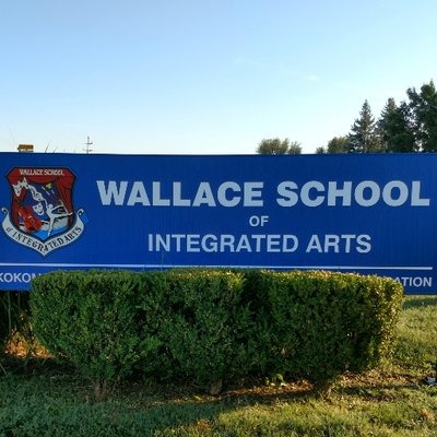 Sign outdoors with wallace school of integrated arts logo