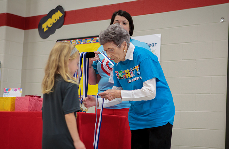 Mrs. Bennett presents a medal of recognition to a student at Bennett Elementary.