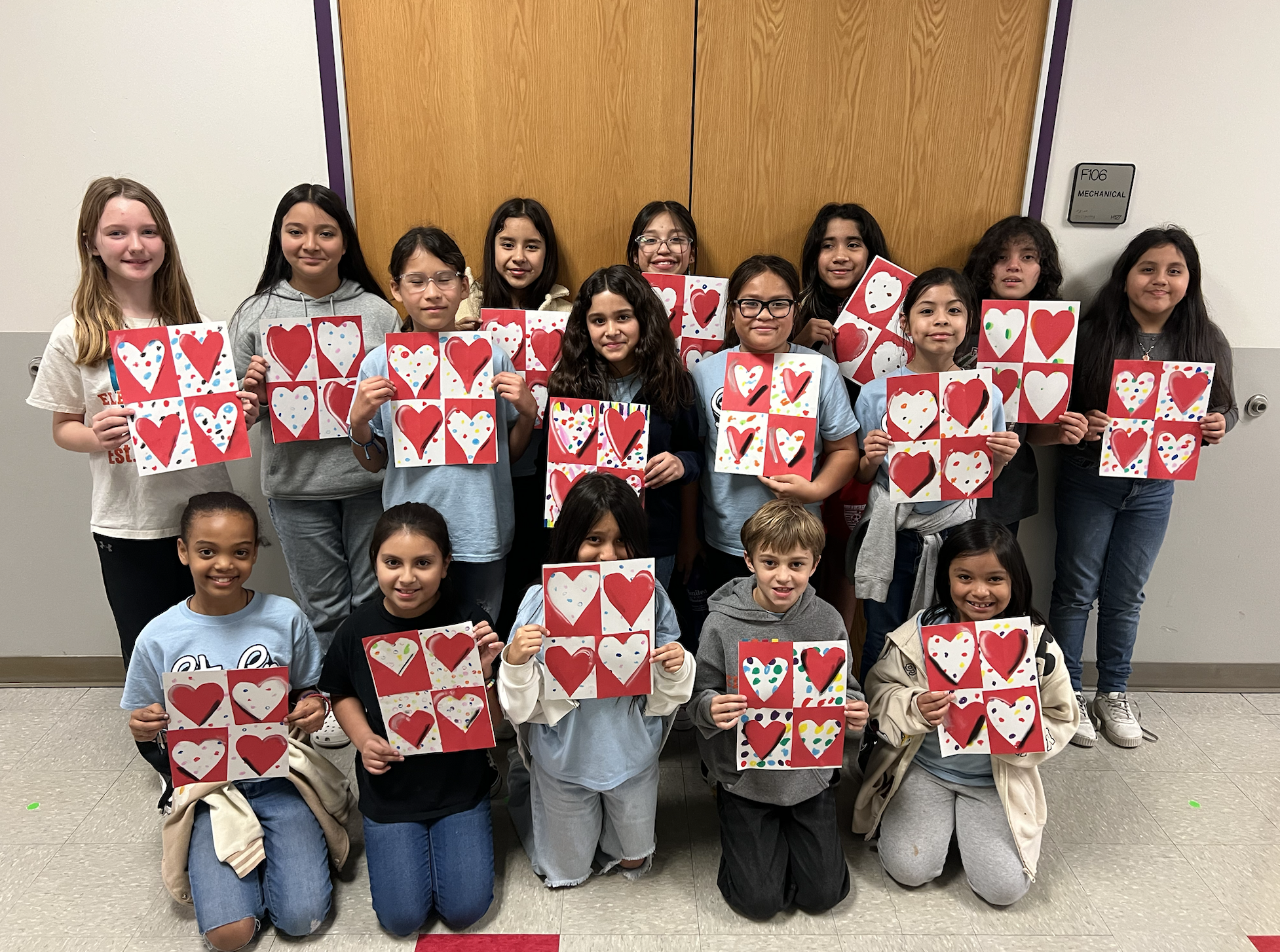 Group of students holding artwork.