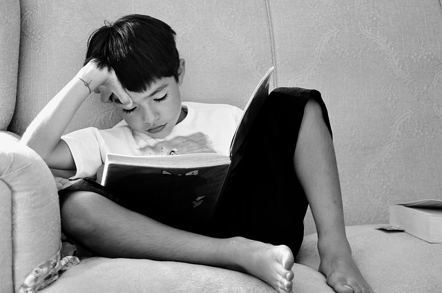 Student sitting on a couch reading a book