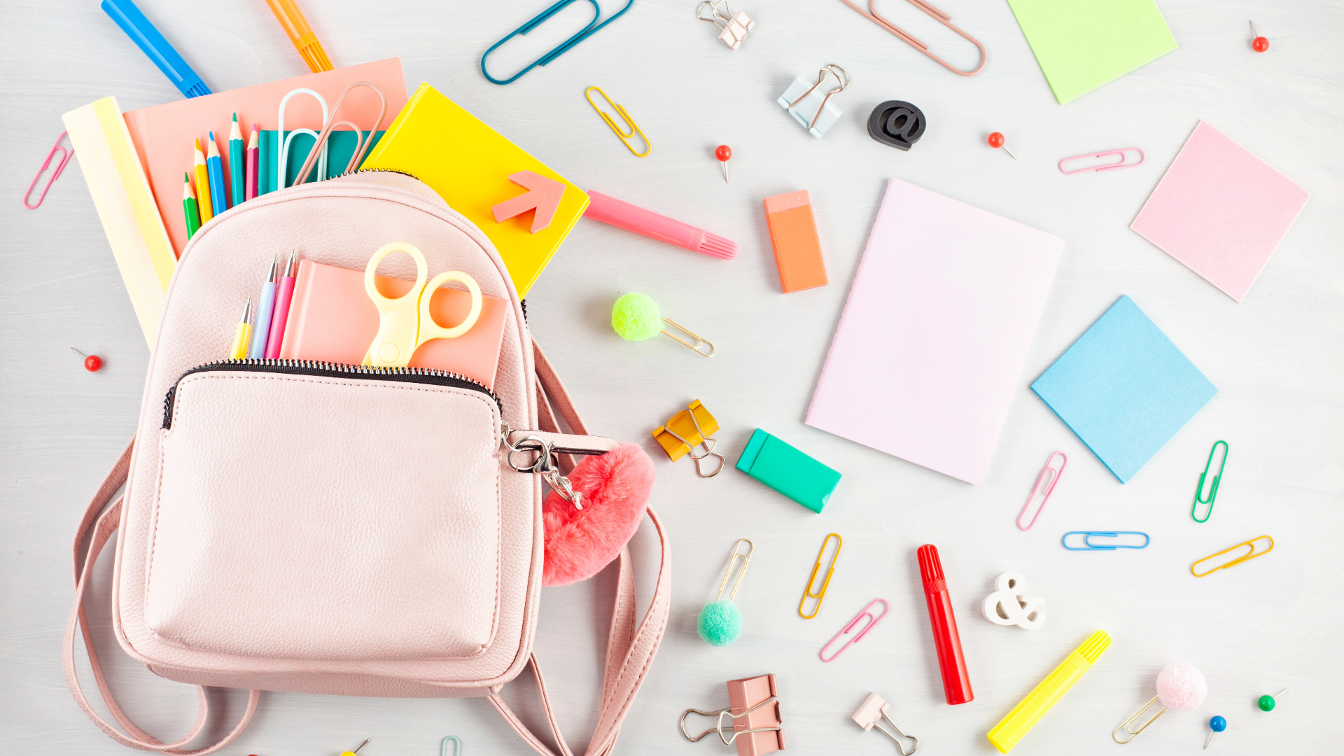 school backpack with various school supplies spilling out