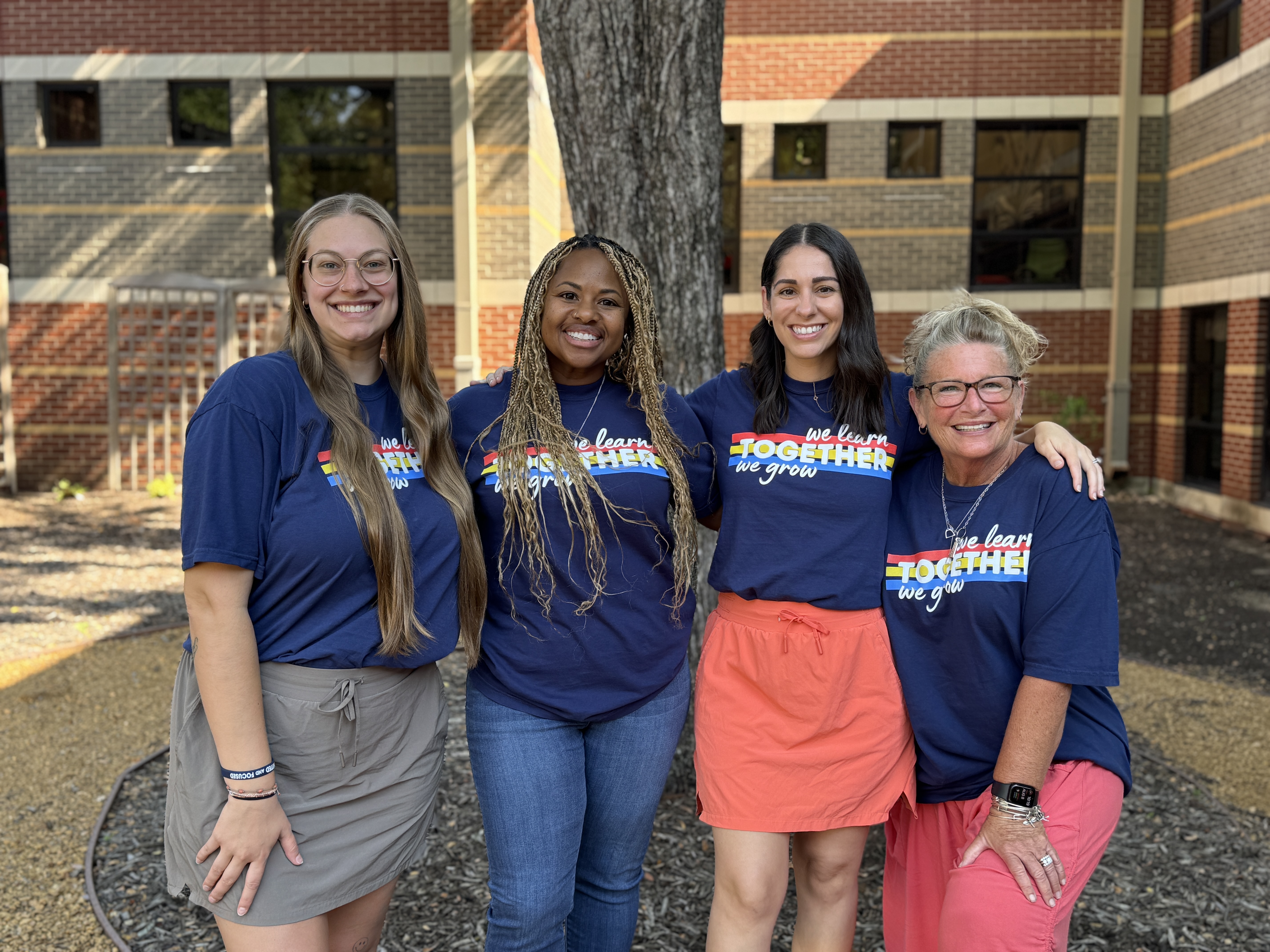 4 kindergarten female teachers in front of a tree