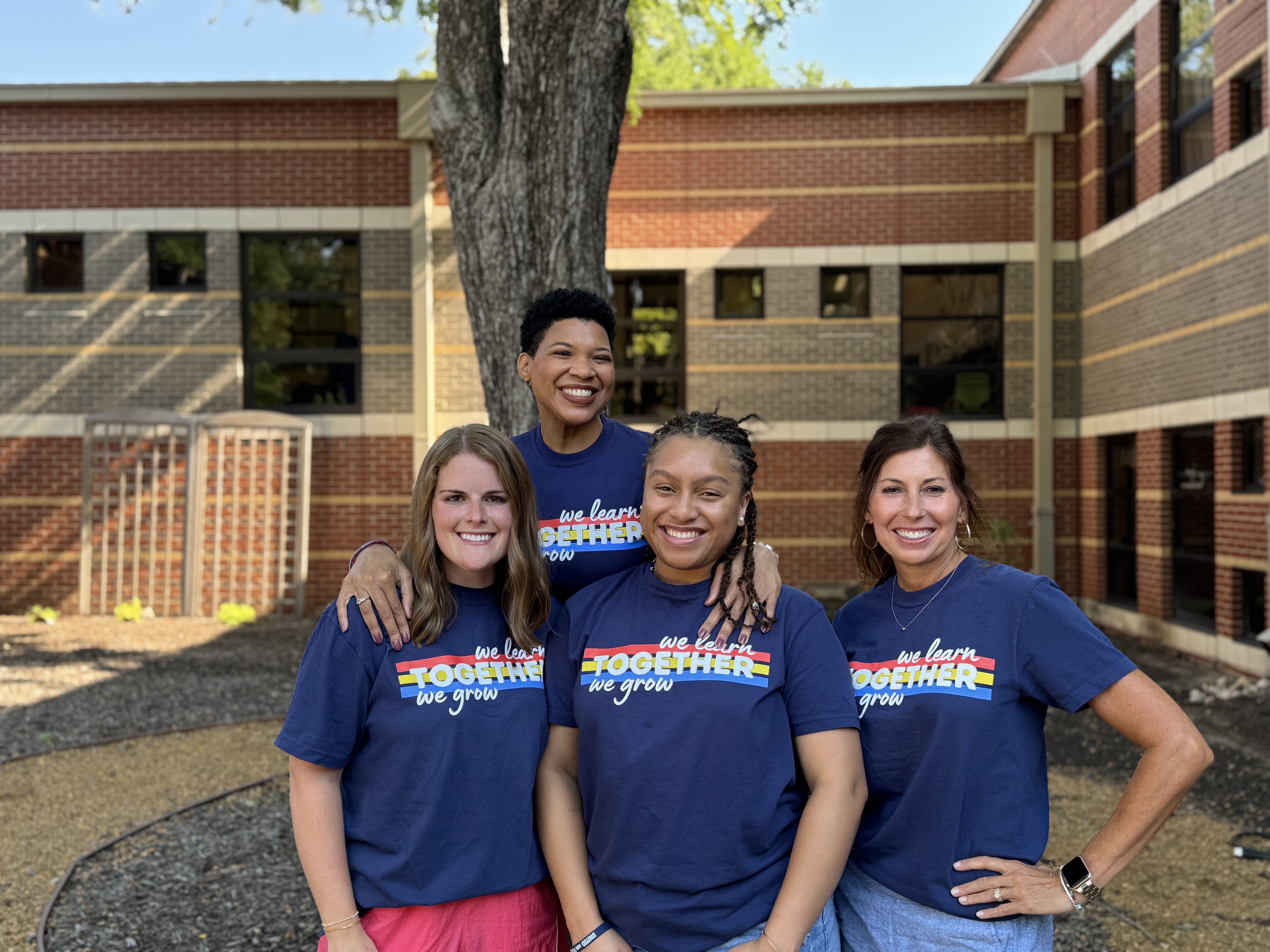 4 female teachers in front of a tree