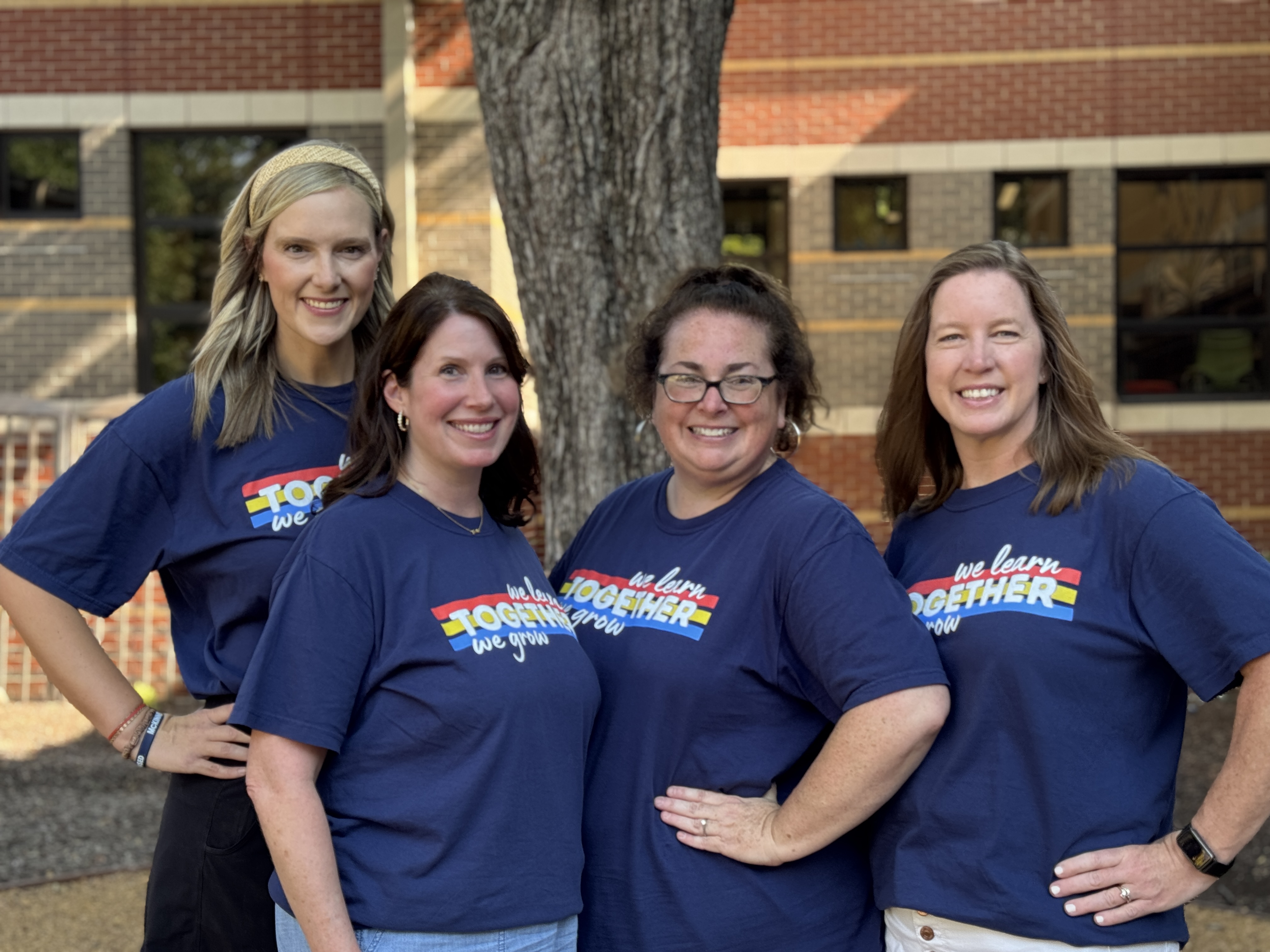 4 female teachers in front of a tree