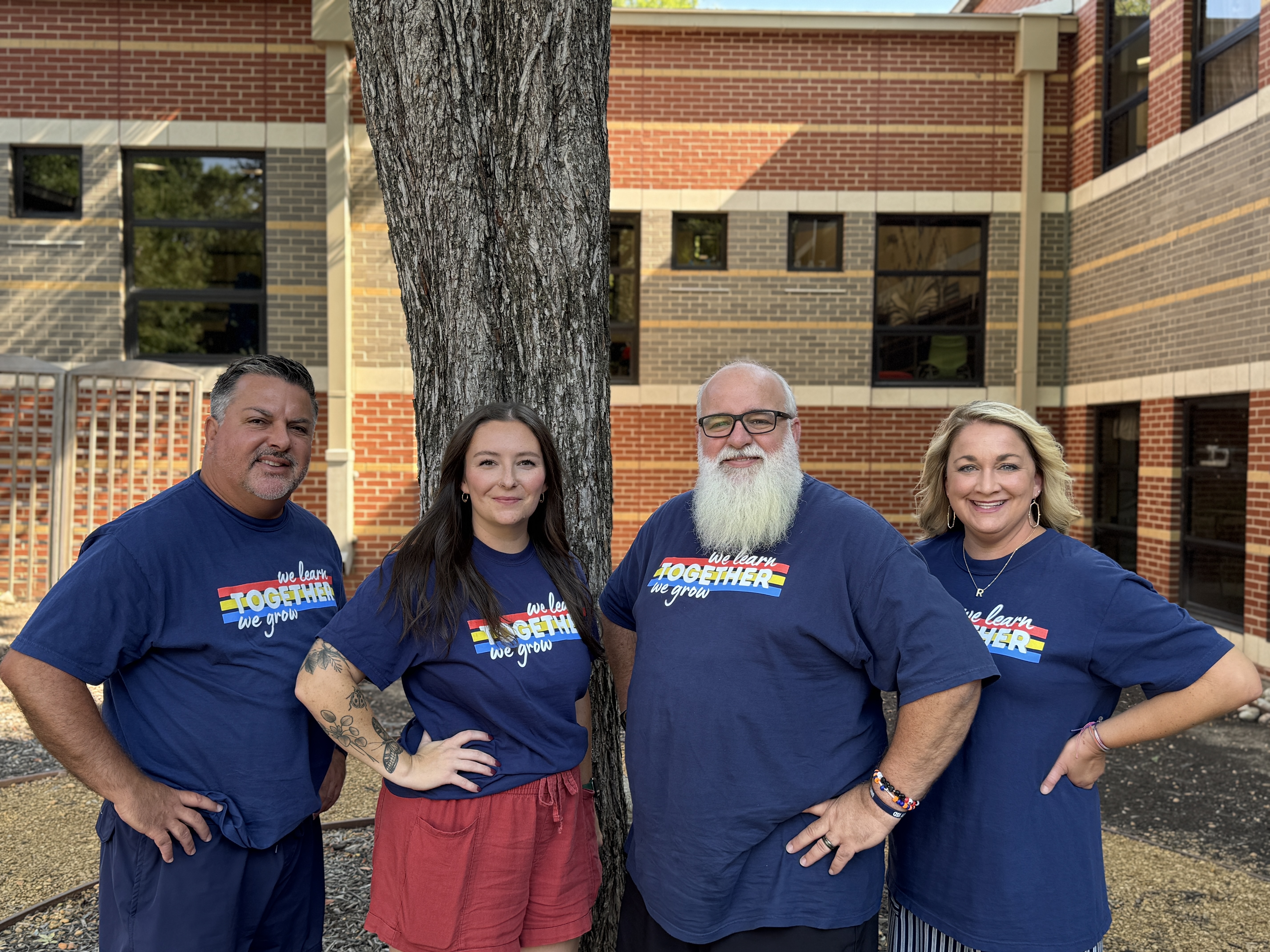 2 female and 2 male teachers in front of a tree