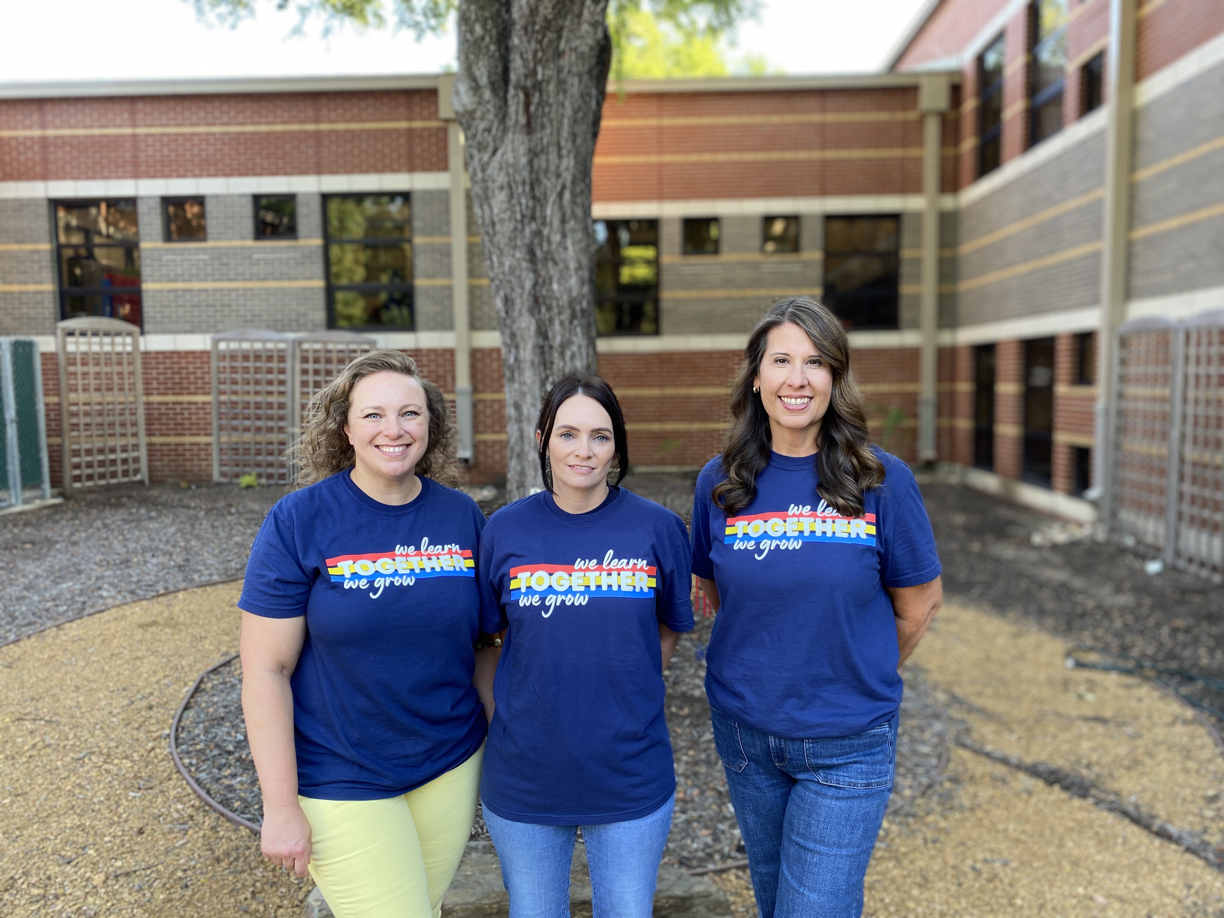 3 ladies standing in front of a tree