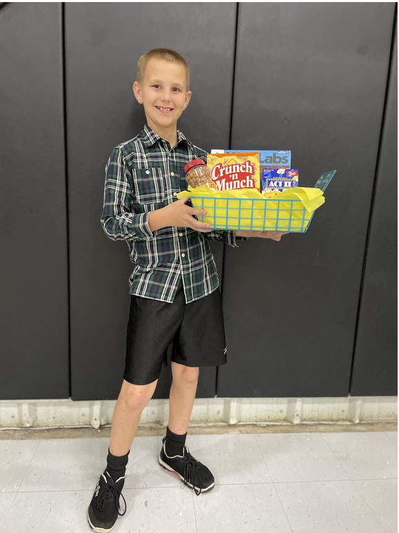 A young boy holding a box of snacks