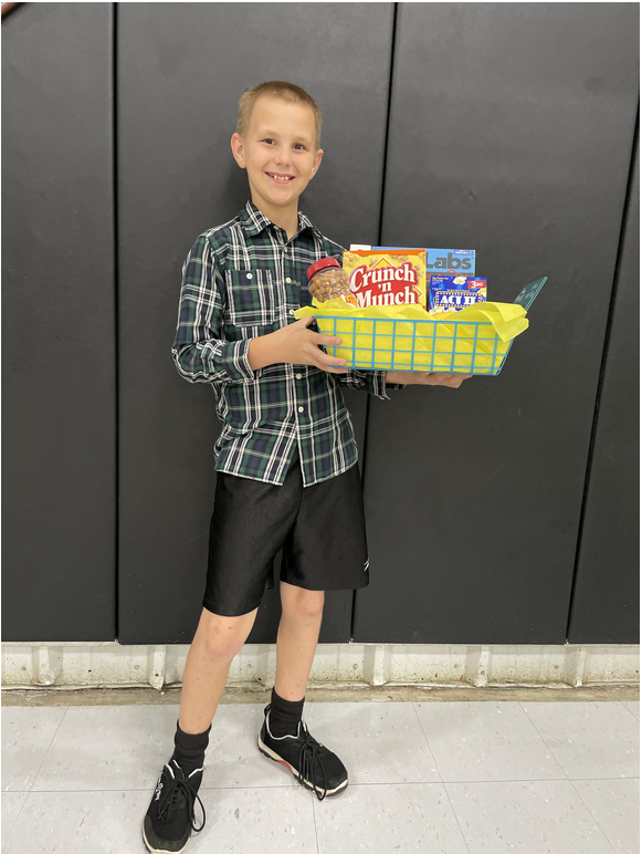 A young boy holding a box of snacks