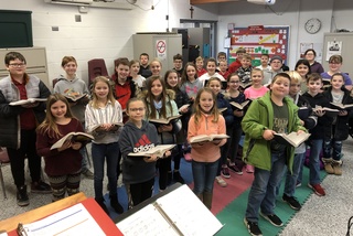 choir students holding sheet music singing