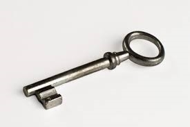 An antique key resting on a plain white background.