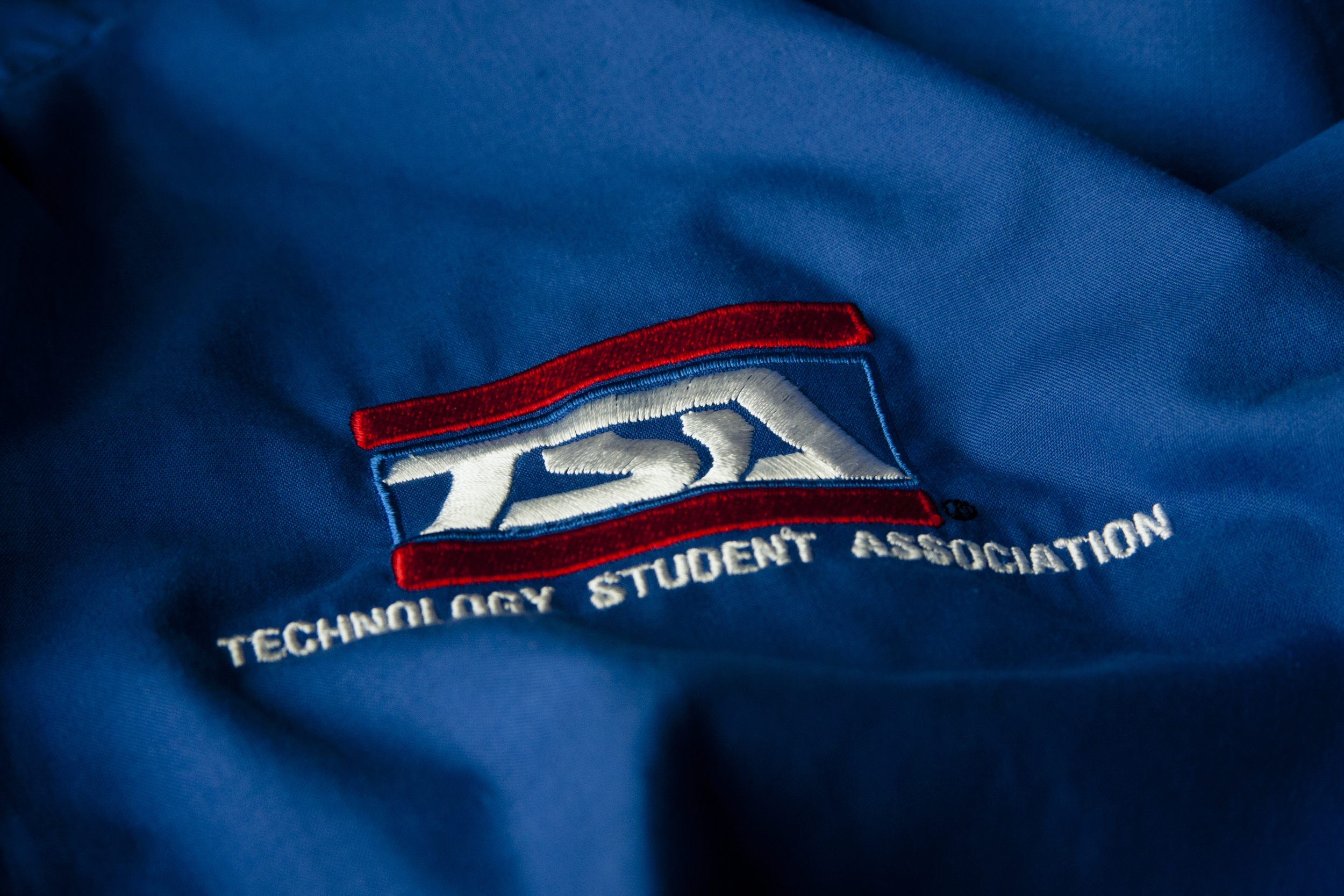 Blue jacket with TSA logo, close-up view.