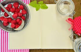 Raspberries and a notebook on a wooden table - a delightful combination of nature's sweetness and creative inspiration.