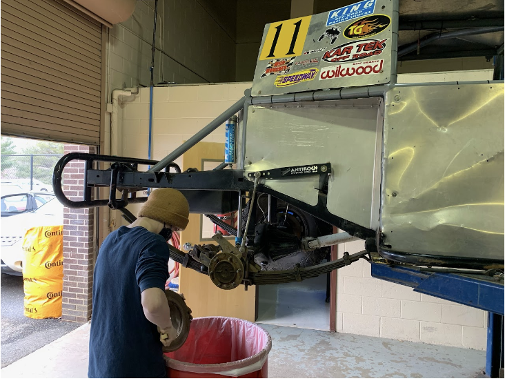 Student working on elevated vehicle