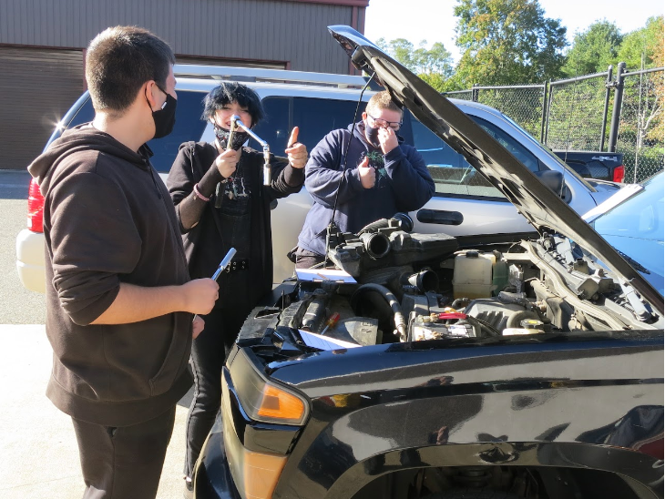 Students working on car engine