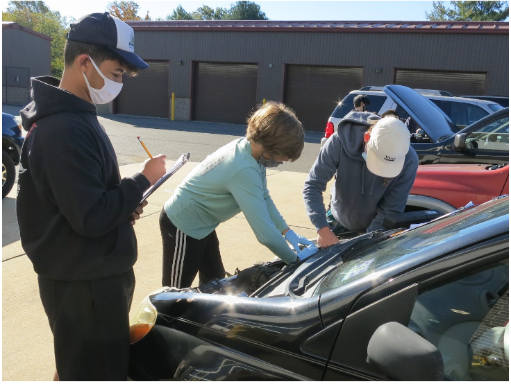 Students working on car engine