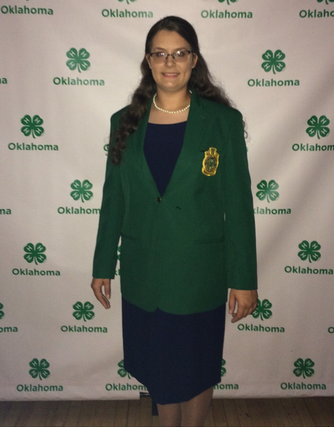 Kallie Clifton posing for a picture with cloverleafs on the background
