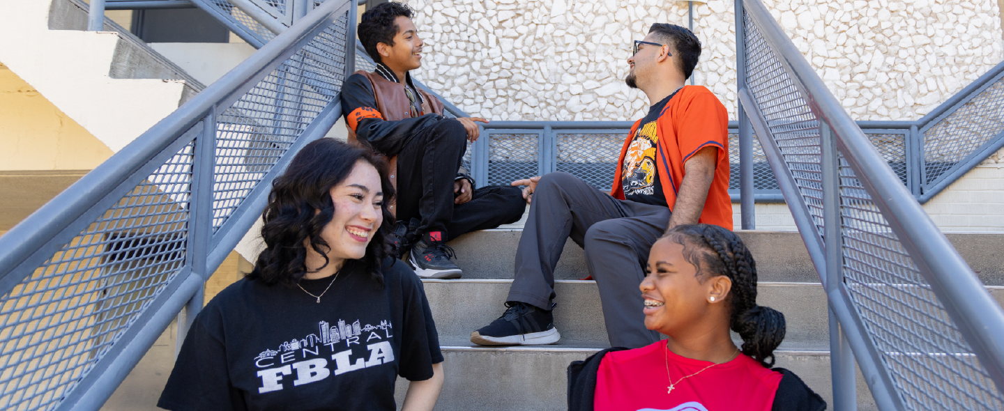 students laughing and talking on staircase