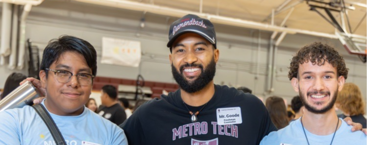 Staf member with two students smiling