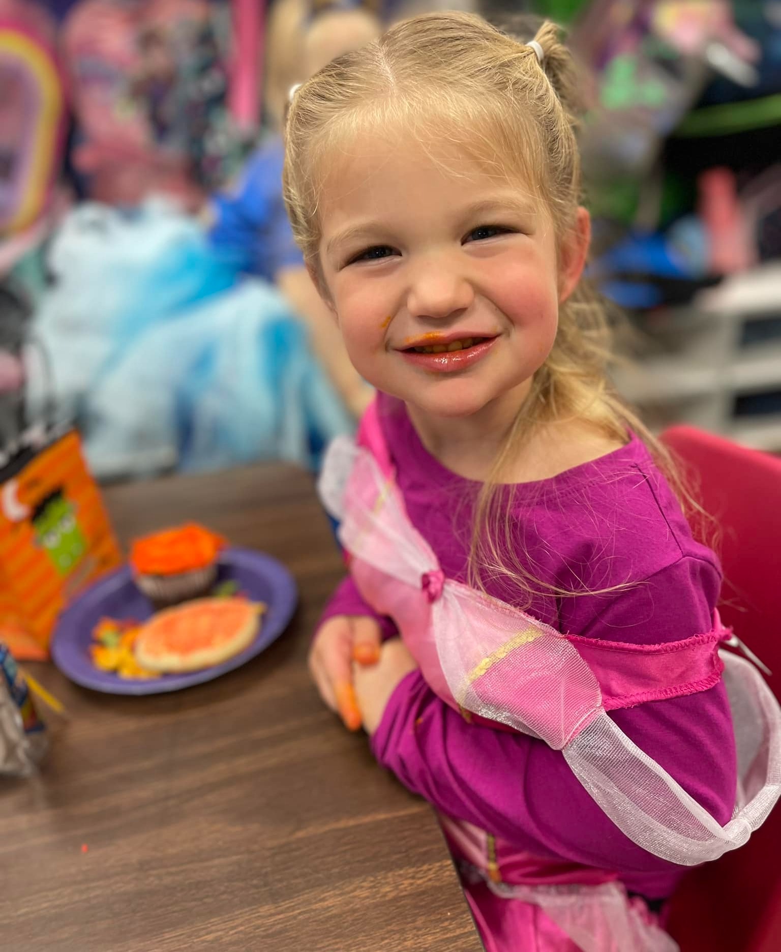 Preschool girl at table eating cookie