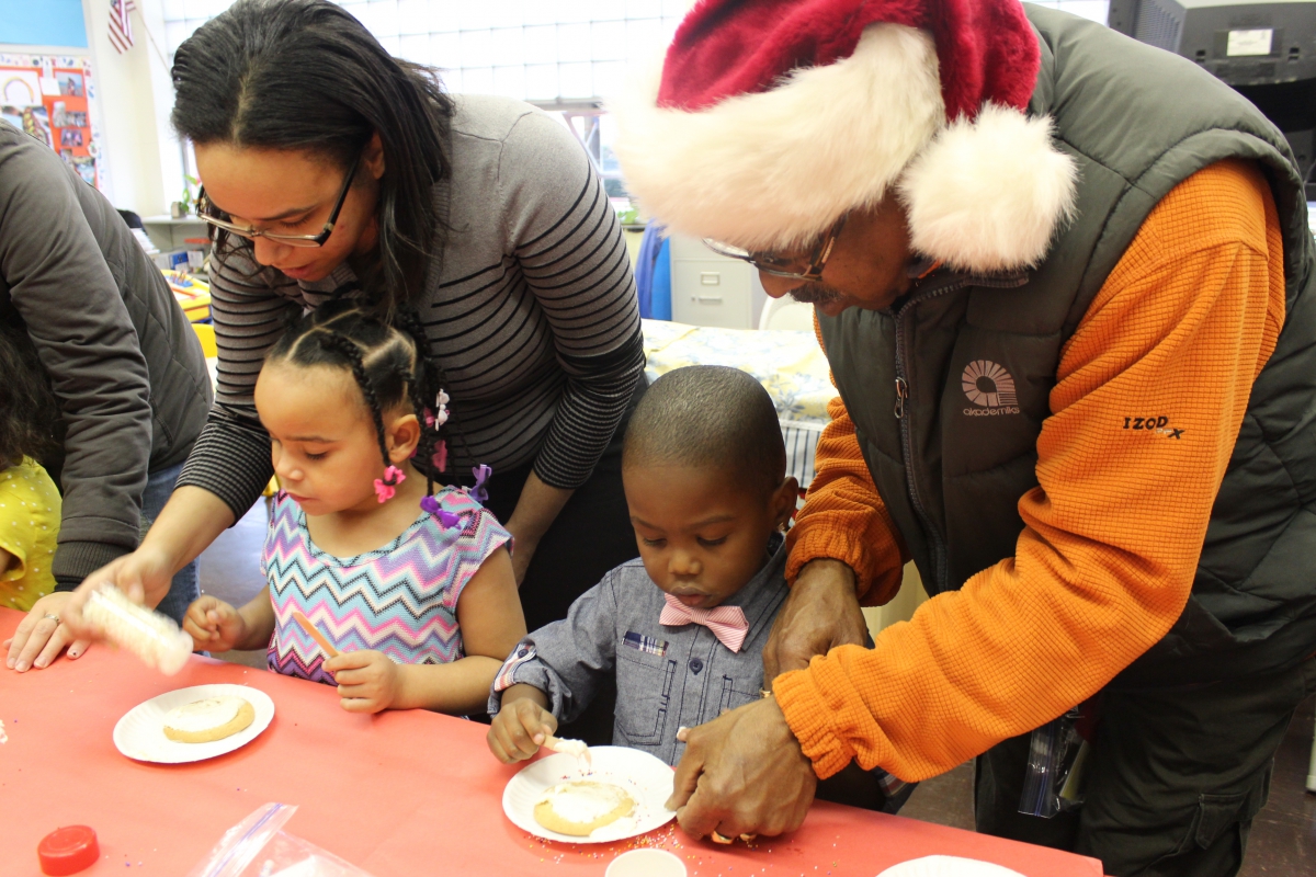 parents with their kids making cookies