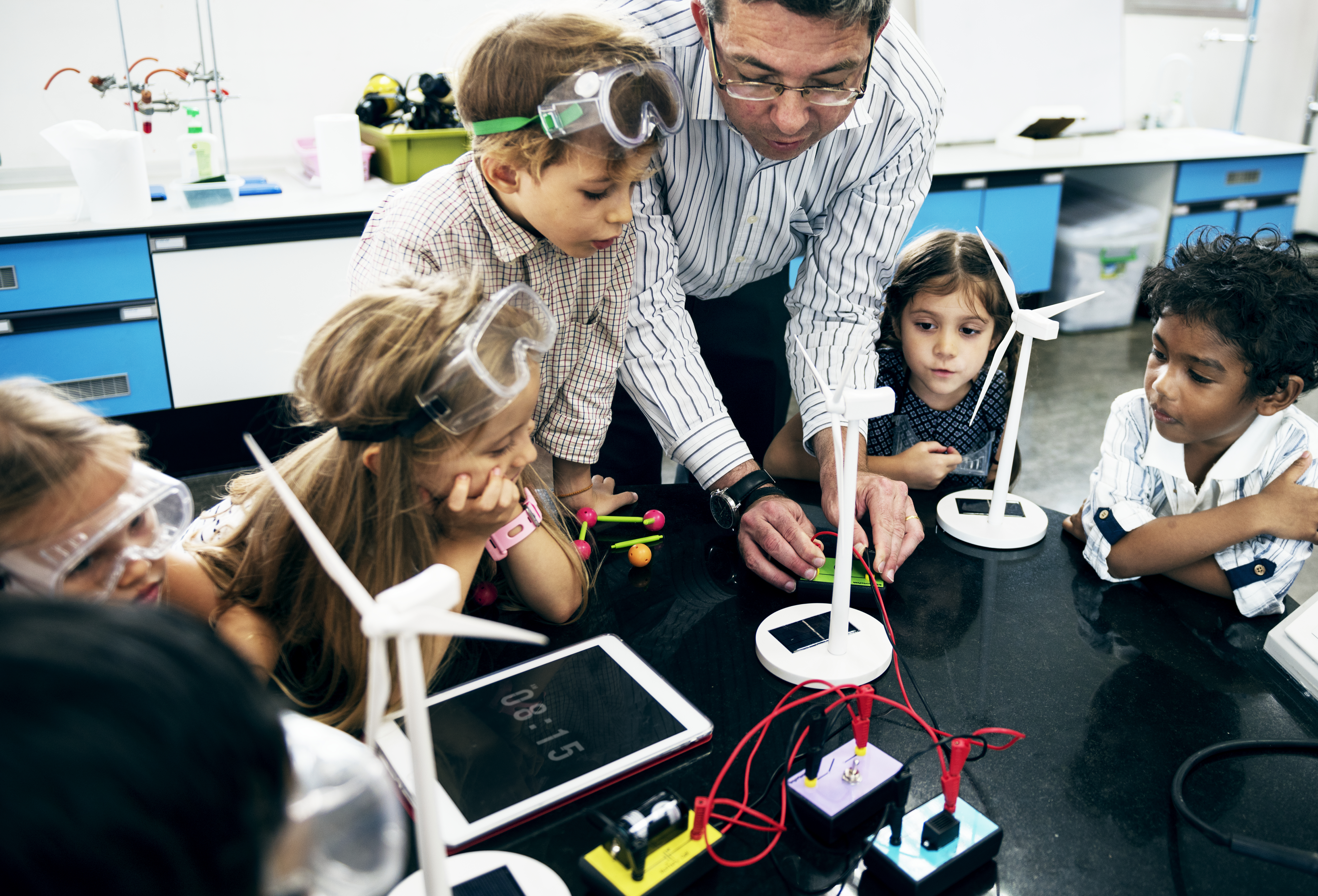 students gathered around teacher doing science project