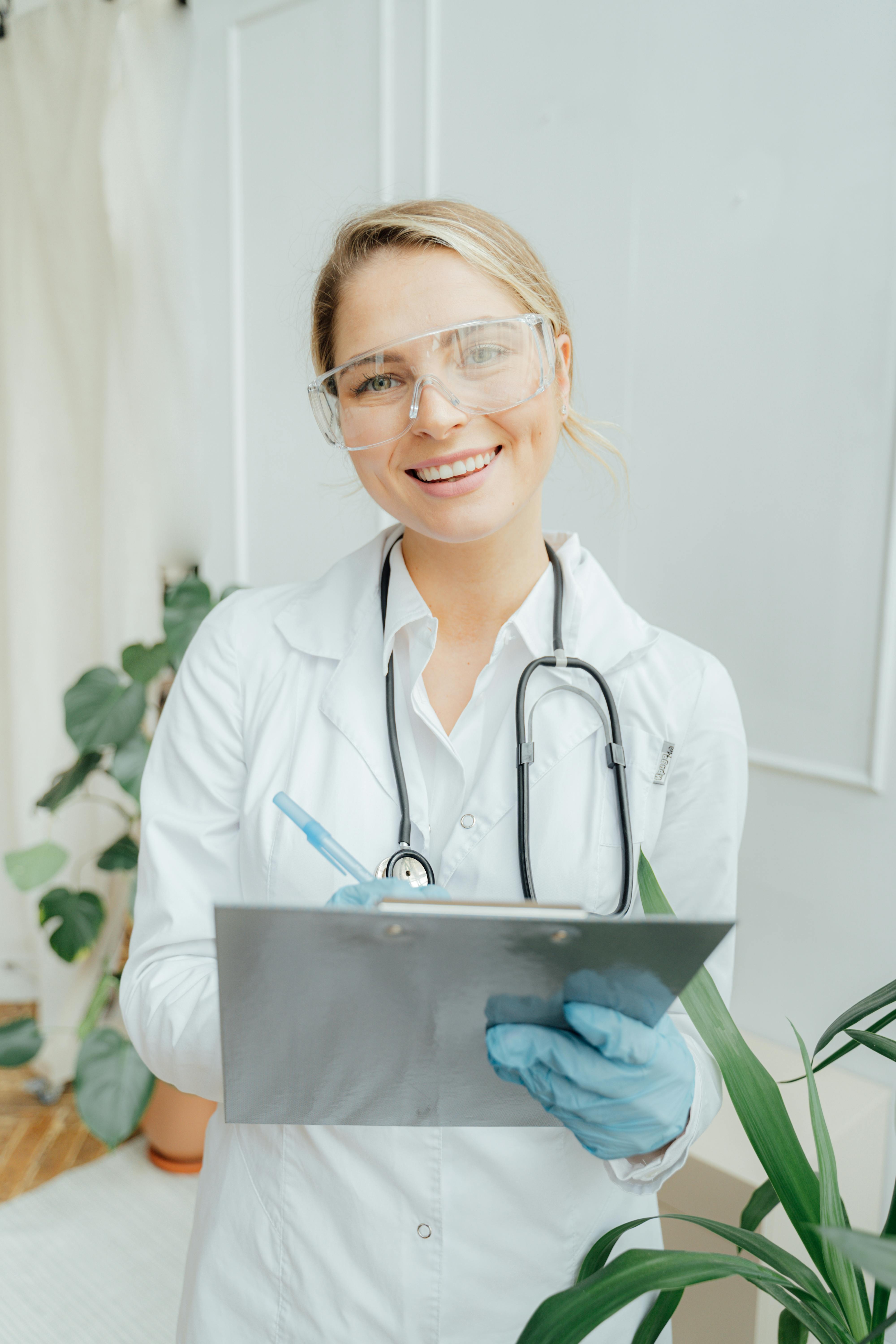 CNA student posing for am picture with clipboard in hand