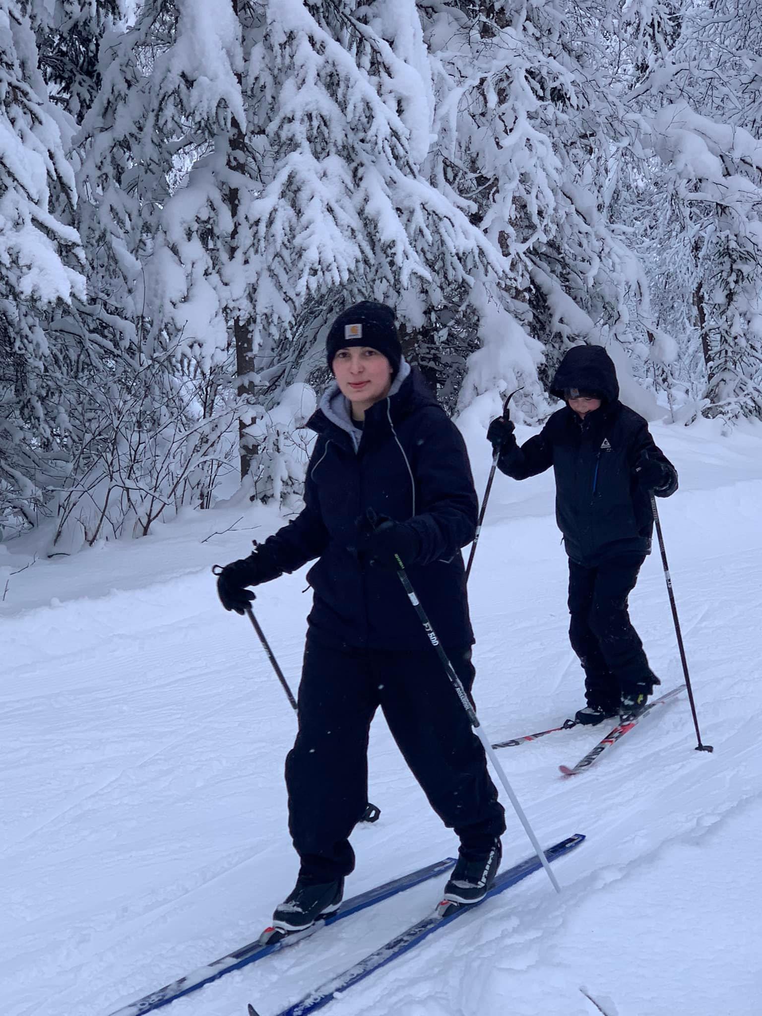 Two skiers gliding down a snowy slope together.