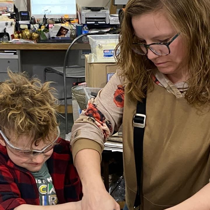 A woman and a boy collaborating on a project, sharing ideas and working together to achieve their goals.