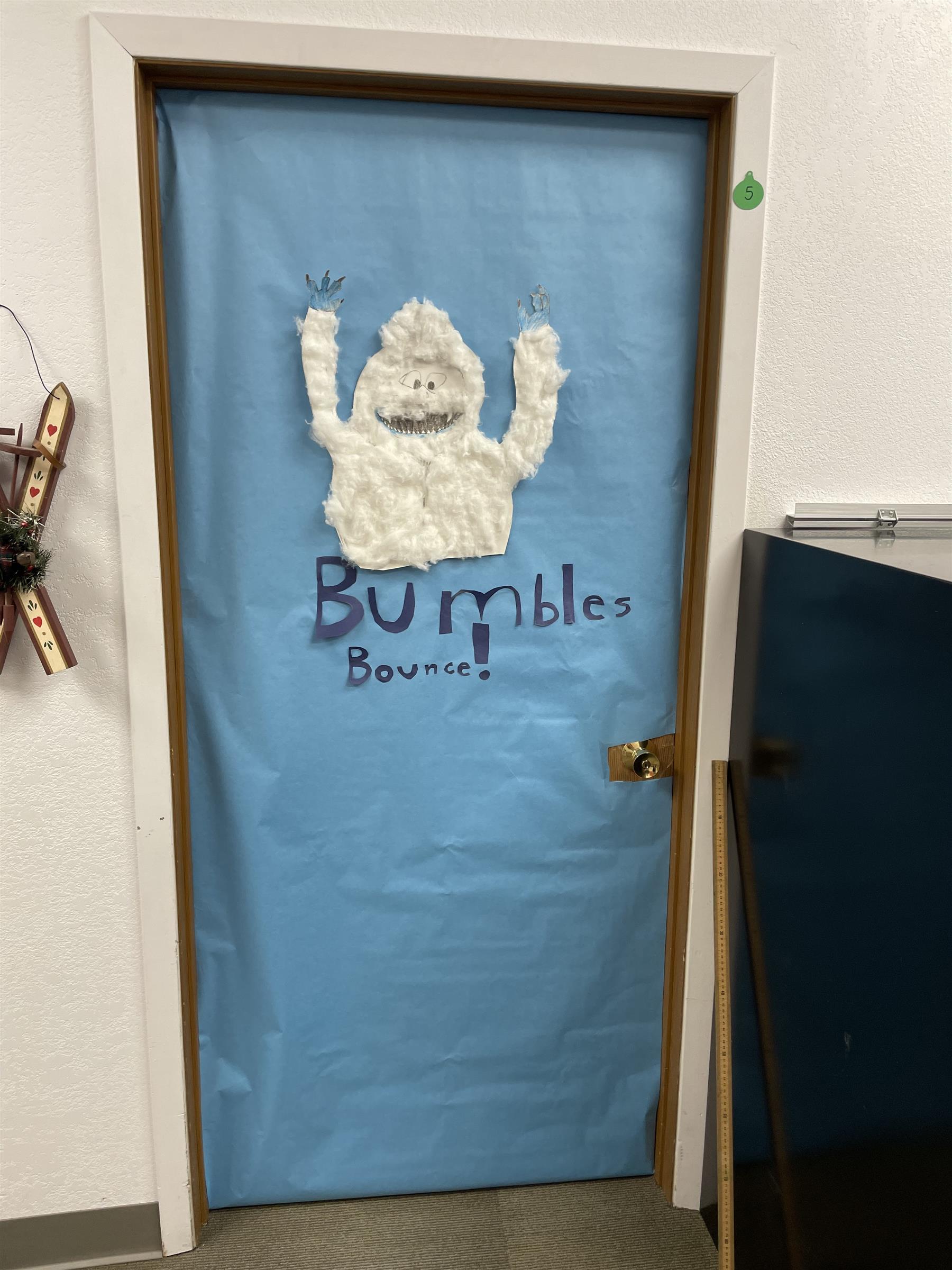 A festive door adorned with a snowman and the word "Bumbles".