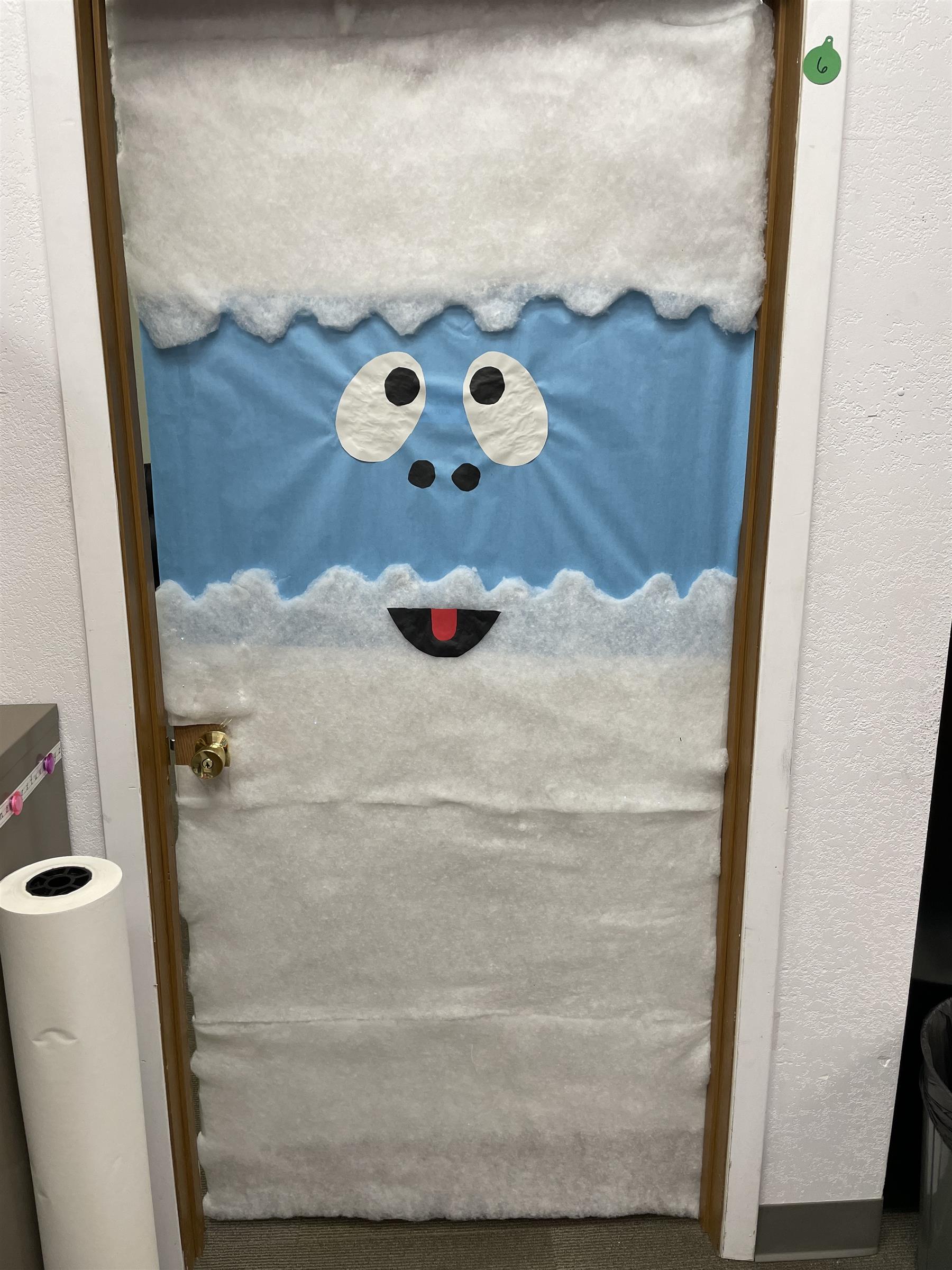 A whimsical door adorned with a face and a snowman, adding a touch of charm and character to the entrance.