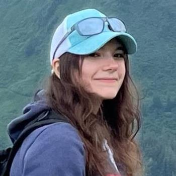 A stylish young woman in a hat and sunglasses, exuding confidence and elegance.