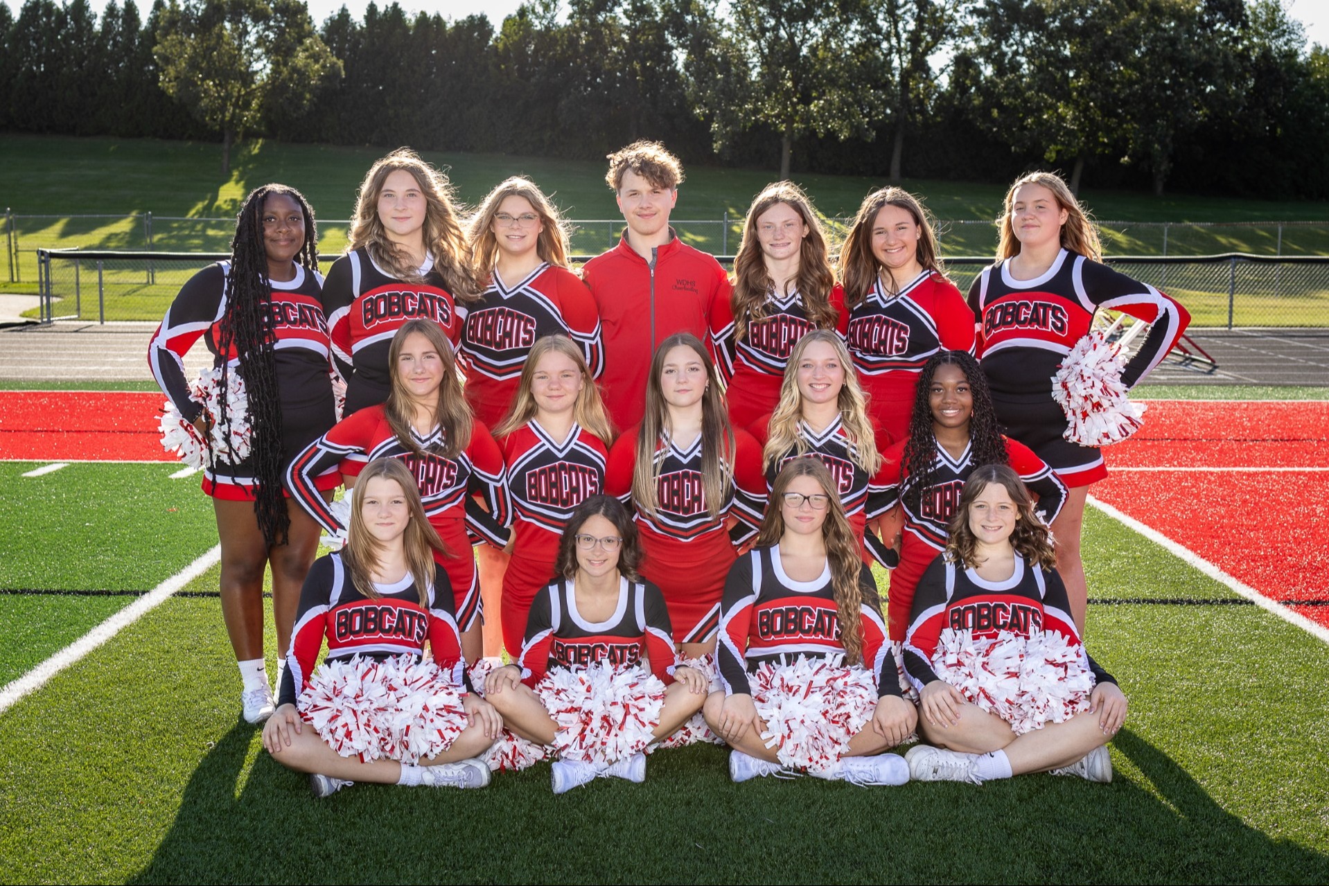 Cheerleaders on the field posing for picture