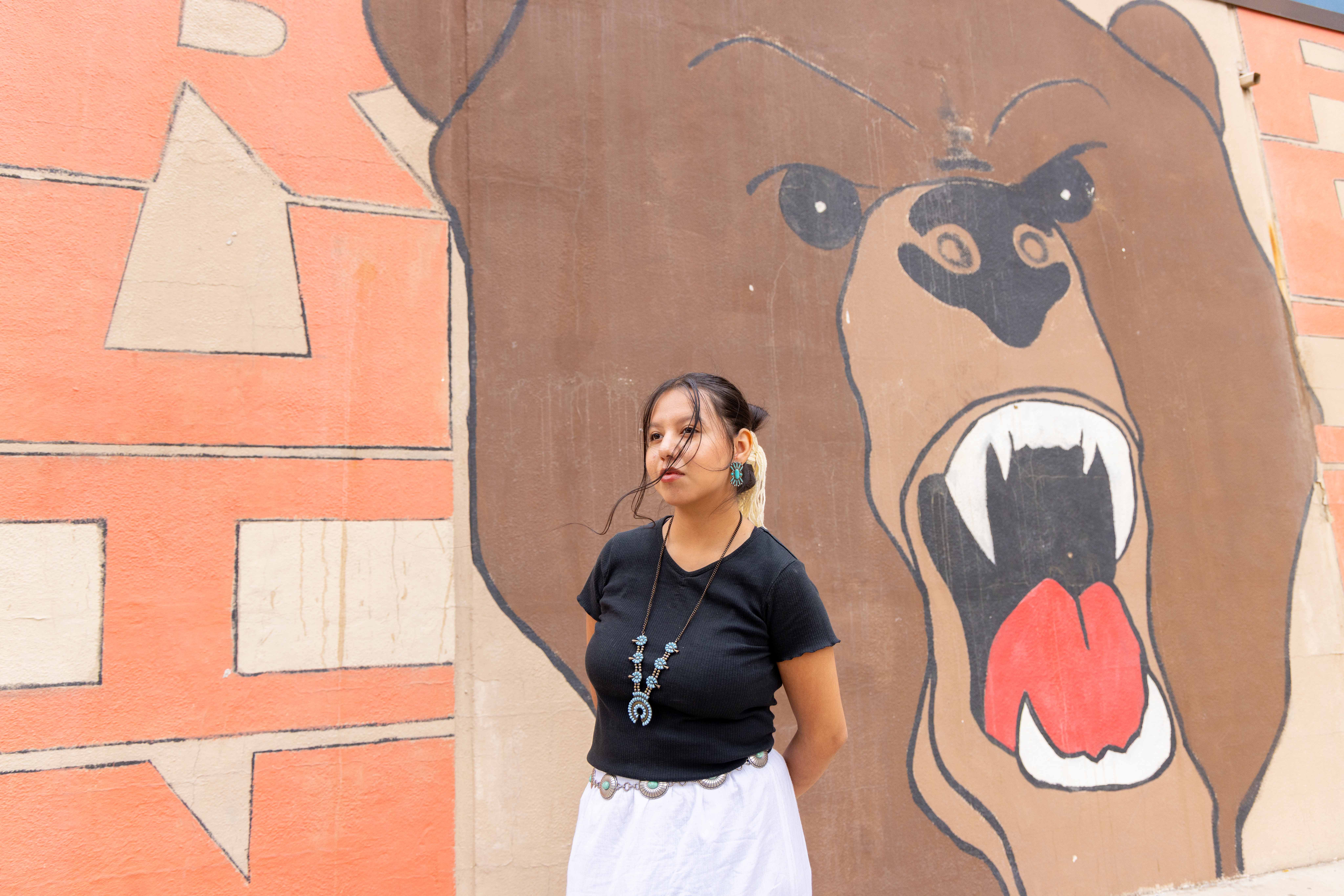Girl in front of bear mural
