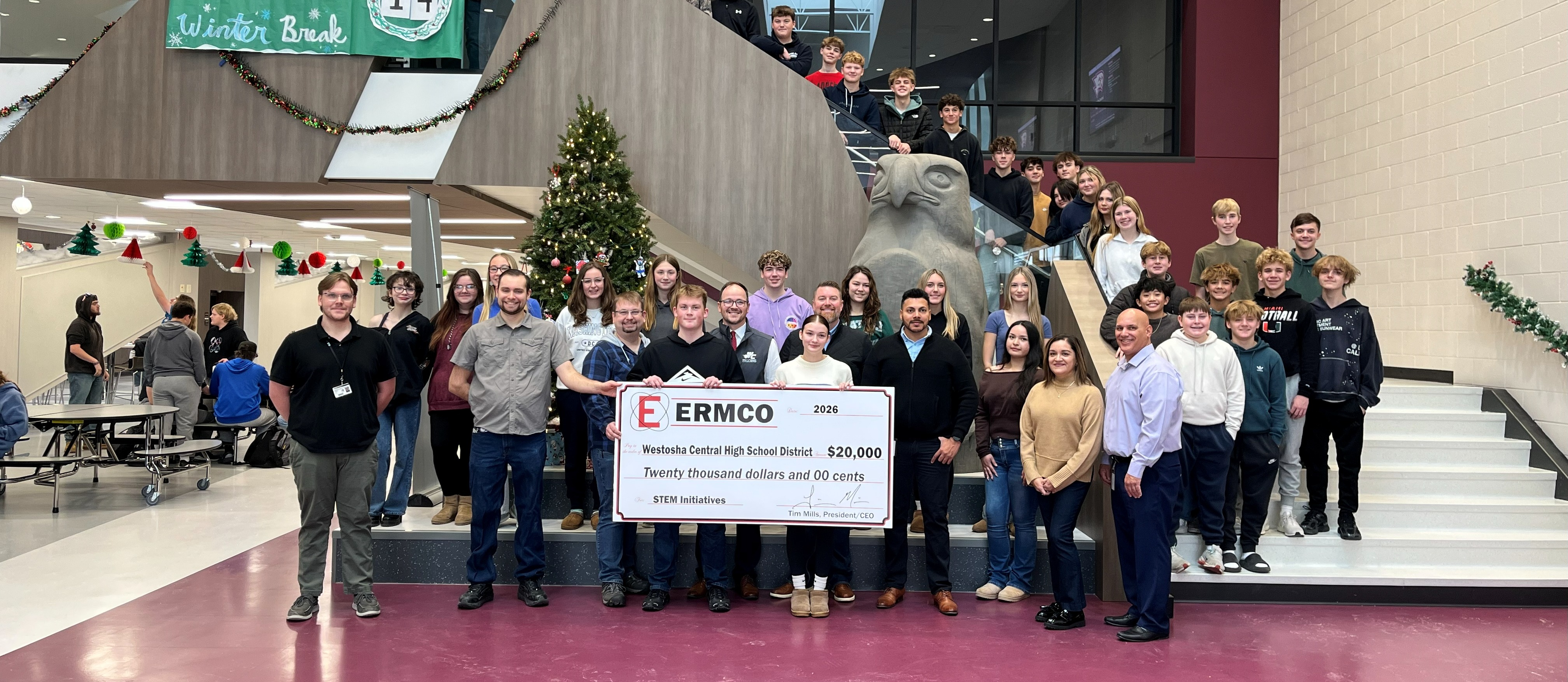 Students and ERMCO Employees posing with check