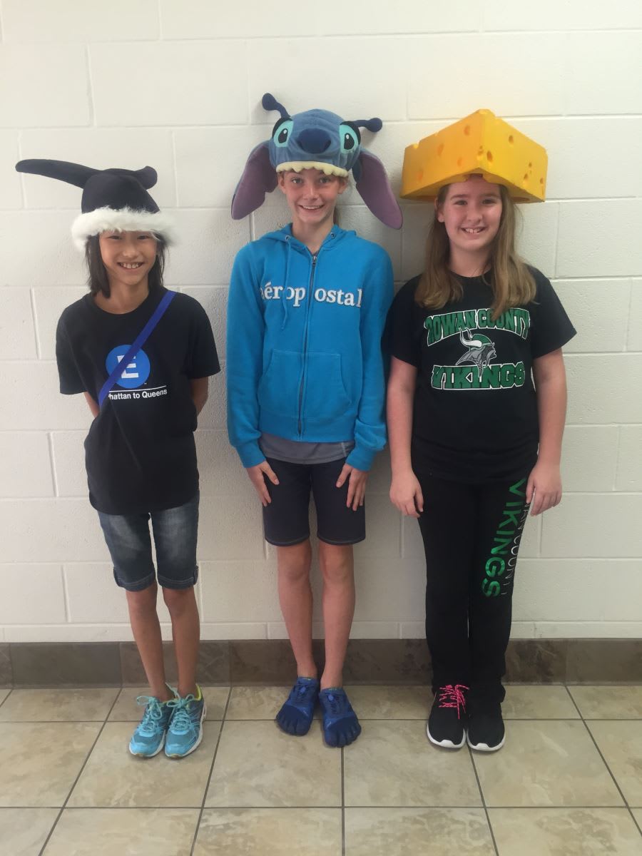 Three young girls standing in front of a wall