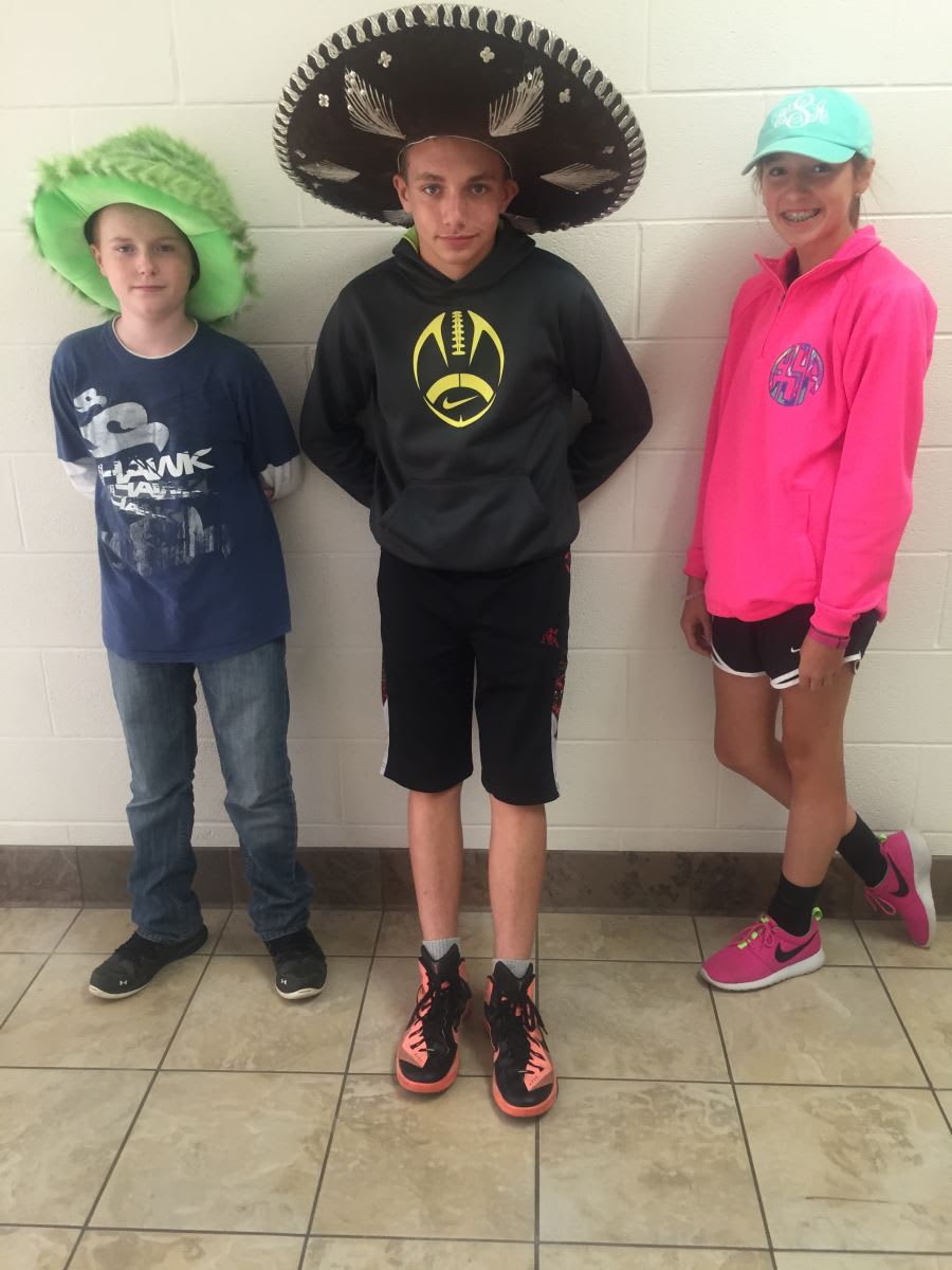 A group of kids standing next to each other in front of a wall