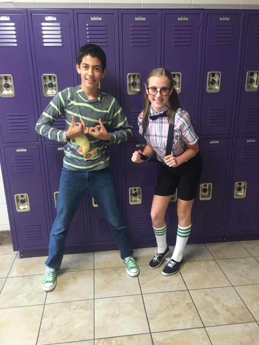 Two children standing in front of a purple locker