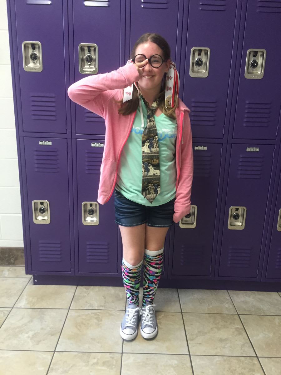 A girl standing in front of a purple locker
