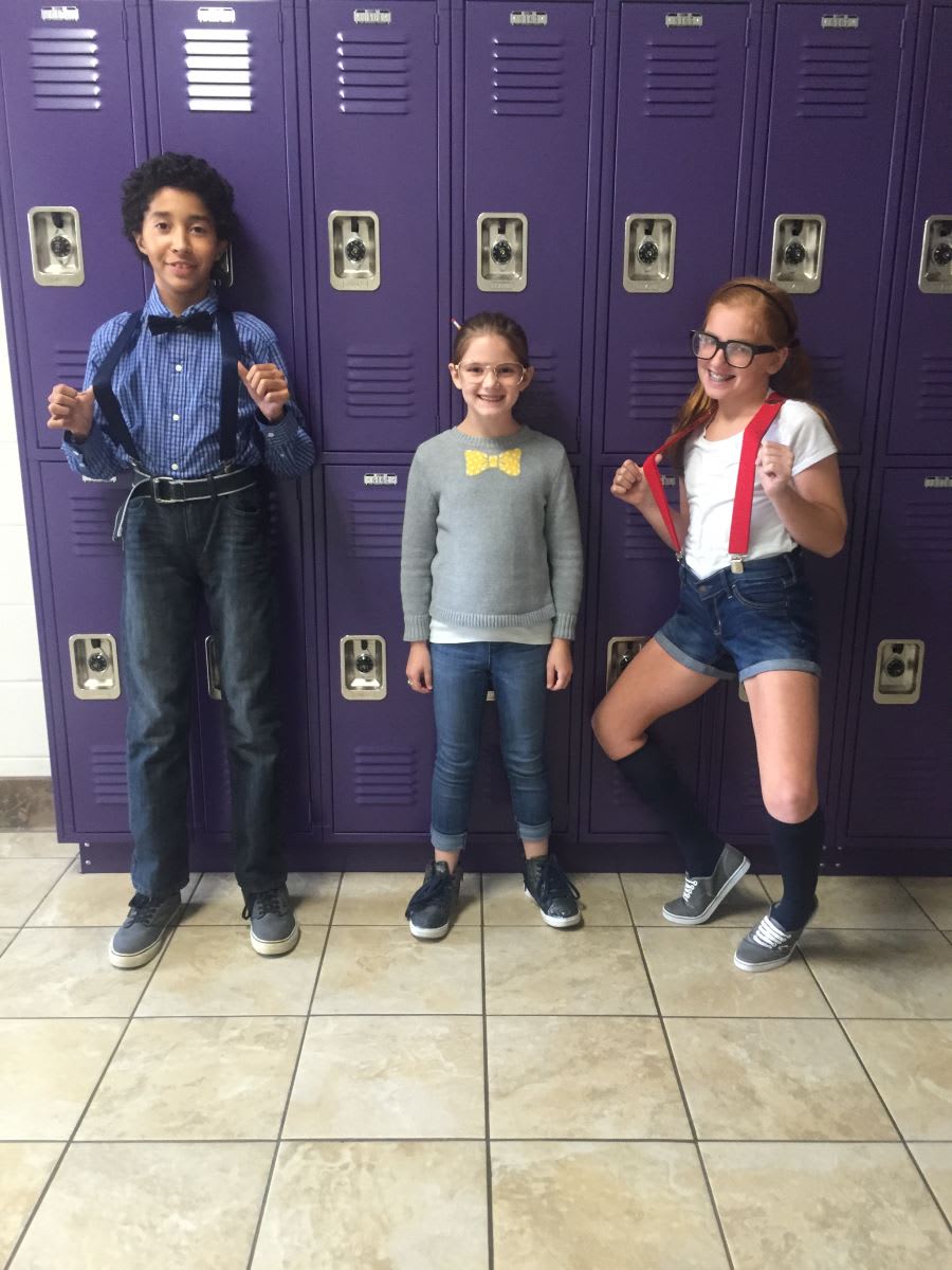 Three children standing in front of a purple locker