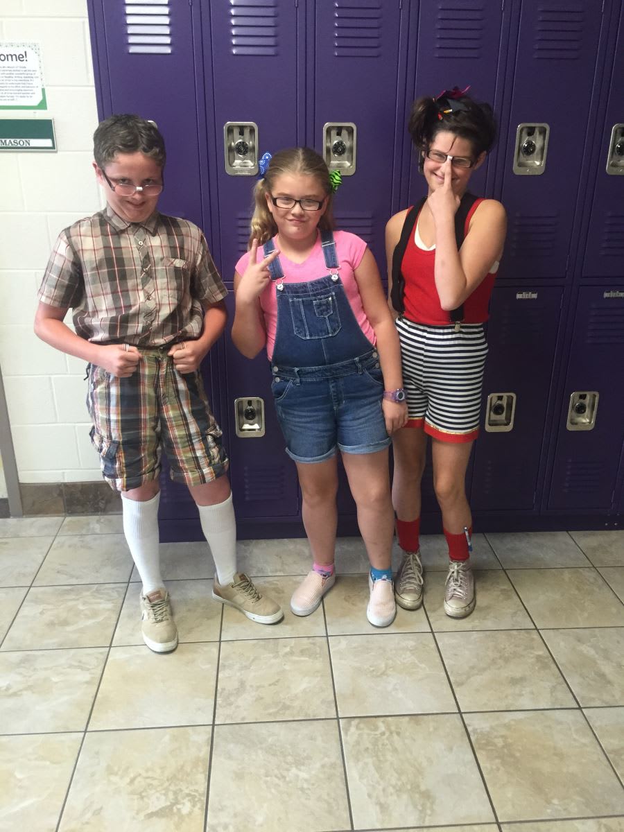 Three children standing in front of a purple locker