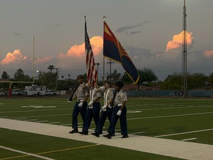 cadets presenting colors with a sunset behind