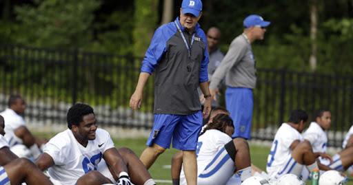 coach with athletes on ground