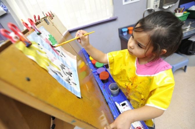 A photo of a kindergarten student painting.